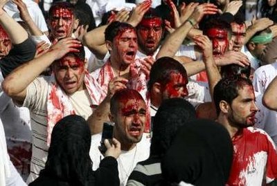 Shi'ite Muslim women take photographs of bleeding men after they were cut on their heads with blades during a ceremony marking Ashura in Nabatieh, south Lebanon, December 27, 2009.