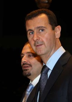 Syrian President Bashar al-Assad (R) walks with Lebanese Prime Minister Saad al-Hariri at the end of their meeting at the Teshrin presidential palace in Damascus December 19,