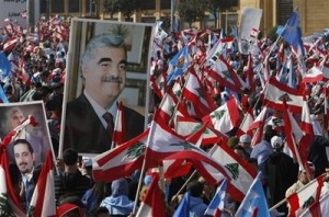 Lebanese people carry national flags and pictures of Lebanese Prime Minister Saad Hariri, left, and his father slain former Prime Minister Rafik Hariri, right, during the  rally