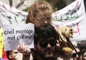 A Lebanese activist carries a sign demanding a secular system  ( Civil  Marriage is not a Civil  war) during a demonstration in front of parliament in Beirut April 25, 2010.
