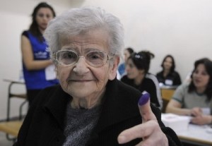 An elderly Lebanese woman shows her inked thumb after casting her ballot during the municipal elections in Amchit on the coast north of Beirut, Lebanon, Sunday, May 2, 2010.