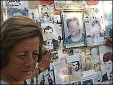 Audette with photographs of those who disappeared, displayed on her tent