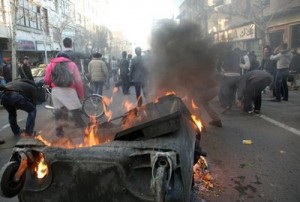 Iranian protestors attending an anti-government protest as a garbage can is set on fire, in Tehran, Iran, Monday, Feb. 14, 2011. Eyewitnesses report that sporadic clashes have erupted in central Tehran's Enghelab or Revolution square between security forces and opposition protesters.