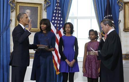 U.S. President Obama takes the oath of office from U.S. Supreme Court Chief Roberts as first lady Michelle holds the bible and daughters Malia and Sasha look on in the Blue Room of the White House in Washington