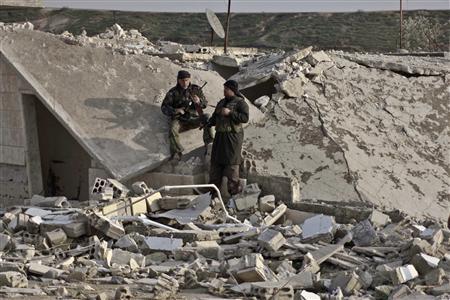 Members of Free Syrian Army take a rest near a damaged house at the front line in Hich village in Idlib