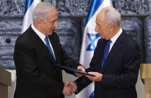 Israeli PM Netanyahu receives a folder from President Peres in a brief ceremony at the president's residence in Jerusalem
