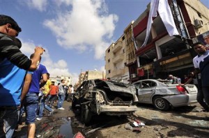 Onlookers take photographs following a car bomb explosion outside a hospital in Benghazi
