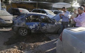 Residents inspect the remain of one of two rockets that hit residential area in Beirut suburbs