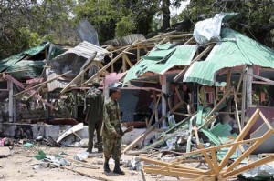 A Somali soldier stands in front of the destroyed Village Restaurant in Hamaerweyne district in Mogadishu