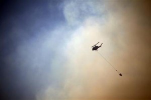 A helicopter drops water on a fire approaching homes near the Blue Mountains suburb of Blackheath