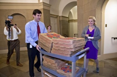 An aide brings a cart stacked with pizza to the office of House Speaker John Boehner Tuesday night after movement toward ending the government shutdown was suddenly halted. 