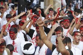 Shiite Muslim men bleed as they gash their foreheads with swords and beat themselves during a ceremony marking Ashoura