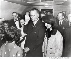 Judge Sarah T. Hughes administering the Presidential Oath of Office to Lyndon B. Johnson aboard Air Force One.