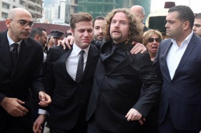 Omar, left, and Ronnie Shatah, the sons  of slain former Finance Minister Mohammad Shatah, embrace during their father 's funeral procession outside of the Mohammad al-Amin Mosque in Beirut, Sunday, Dec. 29, 2013. 