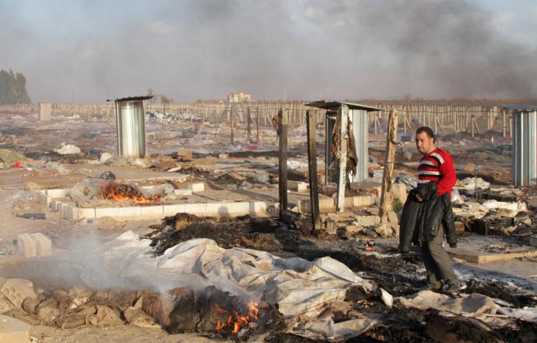 A man walks in a burnt makeshift Syrian refugee camp after it was attacked by residents of the neighboring eastern Lebanese village of Qsarnaba near Zahle in the Bekaa valley on December 2, 2013. (Photo: AFP / STR)