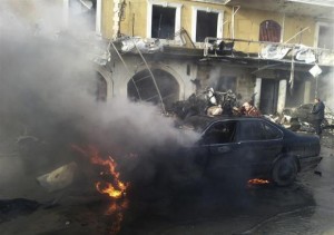 A man reacts near a burning car at the site of an explosion in the Shi'ite town of Hermel