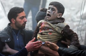 Men help a wounded boy who survived what activists say was an airstrike by forces loyal to Syrian President Bashar al-Assad in the Duma neighbourhood of Damascus