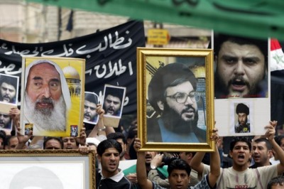 Iraqis Shiite protesters carry up pictures of late Hamas spiritual leader Sheikh Ahmed Yassin (L), Hezbollah secretary general Sheikh Hassan Nasrallah (C) and Iraqi Shiite cleric Moqtada al-Sadr during a demonstration in support of Sadr 06 April 2004 in the southern suburbs of Beirut. (Barrak/AFP/Getty Images)
