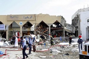 Rescue workers and policemen stand amidst debris near a Turkish restaurant following a gas explosion in Doha