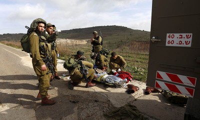 Israeli soldiers prepare to evacuate a comrade injured in a blast on the occupied Golan Heights. -AFP Photo