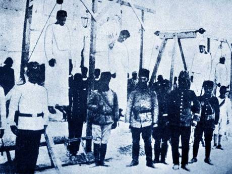 Ottoman soldiers posing in front of Armenians they have hanged