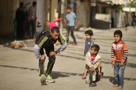 Palestinian Olympic runner Nader Al Masri stretches near his house in Beit Hanoun in the northern Gaza Strip April 10, 2014. Masri, who has participated in 40 international contests including the 2008 Olympics in Beijing, was denied a permit by Israeli authorities to travel to the occupied West Bank for the Palestine Marathon.
