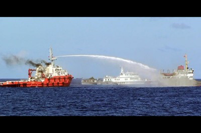 A Chinese ship (l.) shoots water cannon at a Vietnamese vessel (r.) while a Chinese Coast Guard ship (c.) sails alongside in the South China Sea, off Vietnam's coast, Wednesday, May 7, 2014. Vietnam Coast Guard/AP