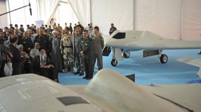 In this picture released by the official website of the office of the Iranian supreme leader, Supreme Leader Ayatollah Ali Khamenei, seated left, listens to an official during his visit at an aerospace exhibition in Tehran, Iran, Sunday, May 11, 2014. The exhibition revealed an advanced CIA spy drone, front, captured in 2011 by Iran, and its Iranian-made copy, back. Khamenei, during the exhibition Sunday, criticized the West for its demands Tehran restrict its missile power, the official IRNA news agency reported. (AP Photo/Office of the Iranian Supreme Leader)