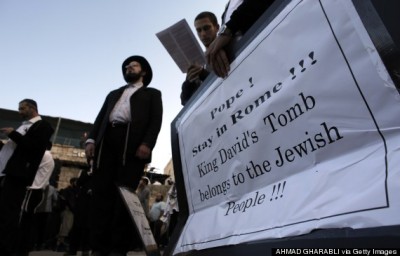 Ultra-Orthodox Jewish men hold placards calling on Pope Francis to stay in Rome, during a protest against his upcoming visit, on May 12, 2014 in the Old City of Jerusalem, near King David's tomb. Hundreds of Orthodox Jewish protesters gathered outside the Old City walls on Mount Zion to protest against Pope Francis' visit to the Holy Land from May 24-26. AFP PHOTO/ AHMAD GHARABLI        