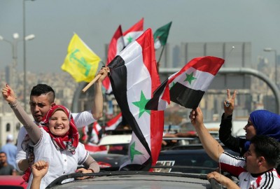Syrians waving flags drive to the Syrian Embassy in Yarze east of Beirut on May 28, 2014, to cast their vote in the presidential elections. Filling the streets around the embassy in Beirut, thousands of Syrians turned out to vote in a controversial presidential election that Bashar al-Assad is expected to clinch effortlessly, as civil war rages. AFP PHOTO/ JOSEPH EIDJOSEPH EID/AFP/Getty Images