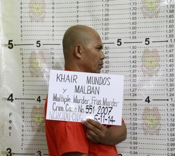In this photo released by the Philippine National Police Public Information Office (PNP-PIO) in Manila, Philippines, Khair Mundos, a top commander of the Abu Sayyaf extremist group who is on the U.S. list of most-wanted terrorists and has acknowledged receiving al-Qaida funds to finance bombings in the country, undergoes a police booking procedure following his capture near Manila's international airport Wednesday, June 11, 2014. Philippine security officials said Mundos was arrested in a slum community near Manila's international airport but it was not immediately clear why he was in the capital. The military and police have been hunting him for his alleged involvement in bombings and kidnappings.  (AP Photo/Philippine National Police Public Information Office)