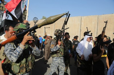 Shiite tribal fighters raise their weapons and chant slogans against the al-Qaida-inspired Islamic State of Iraq and the Levant (ISIL) in the northwest Baghdad's Shula neighborhood, Iraq. (Karim Kadim/AP)