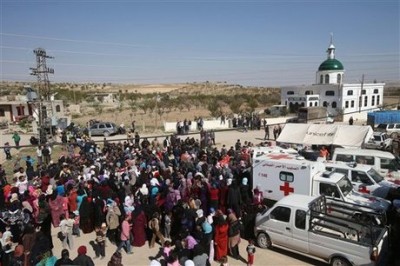 Lebanese and Syrian citizens gather to receive aid supplies, at the main square of Tfail village at the Lebanese-Syrian border, eastern Lebanon, Tuesday April 22, 2014. A Lebanese convoy of soldiers, clerics and Red Cross officials delivered aid Tuesday to a remote village near the Syrian border that was bombed by Syrian government aircraft and blocked by Lebanese militants fighting alongside President Bashar Assads forces in the civil war next door. Hezbollah fighters have been patrolling the area on the Lebanese side and fighting has flared up inside Syria, cutting Tfails residents off from all sides for months. (AP Photo/Hussein Malla)