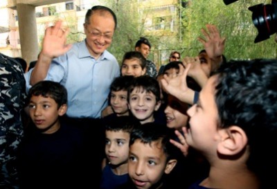 World Bank President Jim Yong Kim, left, waves as he stands next to Syrian refugee students, at a Lebanese public school, in Burj Hammoud area, east Beirut, Lebanon, Tuesday, June 3, 2014. Kim is on an official visit to Lebanon aimed at supporting the tiny Arab country which is hosting over a million Syrian refugees. (Hussein Malla/Associated Press)