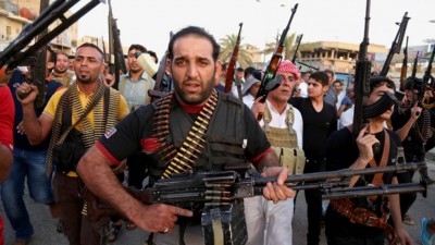Iraqi Shiite tribal fighters deploy with their weapons while chanting slogans against the Al Qaeda-inspired Islamic State of Iraq and the Levant (ISIS), to help the military, which defends the capital in Baghdad's Sadr City, Iraq.AP