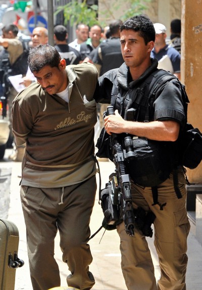 Security forces' arrested one of the suspects and led him away from the hotel. Credit Wael Hamzeh/European Pressphoto Agency