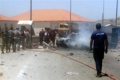 Lebanese firefighters extinguish a flame on a vehicle at the site of an explosion near a police checkpoint in the eastern town of Dahr el-Baidar, Lebanon, Friday, June 20, 2014. A suicide bomber detonated his vehicle Friday near a police checkpoint in eastern Lebanon, killing a few people amid heightened concerns of renewed violence, the country's state-run news agency and security officials said. (AP Photo)