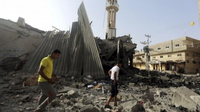 Palestinians gather around the ruins of the Al-Tawfeeq mosque after it was hit by an Israeli missile strike in the Nuseirat refugee camp, central Gaza Strip 
