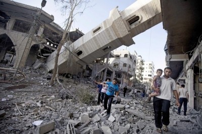 Palestinians walk past the collapsed minaret of a destroyed mosque in Gaza City on July 30 after it was hit in an overnight Israeli strike. AFP Photo