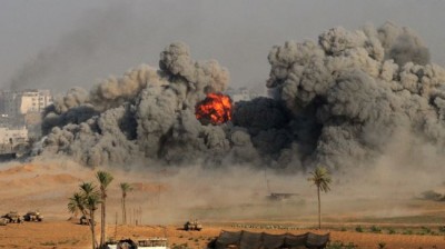 A fire ball and smoke is seen during an Israeli strike on Gaza City early on July 26, 2014.