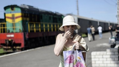 A woman covers her mouth with a piece of fabric to protect herself from the smell as she walks near railway wagons which according to employees and local residents contains bodies of passengers of the Malaysia Airlines plane which crashed in eastern Ukraine three days ago, at a railway station on July 20, 2014 in the town of Torez. The missile system used to shoot down a Malaysian airliner was handed to pro-Russian separatists in Ukraine by Moscow, the top US diplomat said Sunday. AFP PHOTO/ BULENT KILICBULENT KILIC/AFP/Getty Images