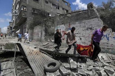 Palestinians run as they flee Gaza City's Shijaiyah neighborhood that came under fire as Israel widened its ground offensive against Hamas in the Gaza Strip on Sunday. Tens of people were killed in Shijaiyah and many more bodies were believed buried under the rubble of homes, health officials said. LEFTERIS PITARAKIS — AP 