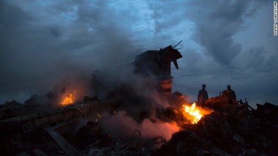 People walk amongst the debris at the crash site of a passenger plane near the village of Grabovo, Ukraine, Thursday, July 17, 2014. Ukraine said a passenger plane carrying 295 people was shot down Thursday as it flew over the country, and both the government and the pro-Russia separatists fighting in the region denied any responsibility for downing the plane. (AP Photo/Dmitry Lovetsky)