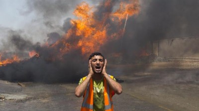 Palestinian firefighters try to extinguish a blaze at a United Nations storehouse after an Israeli military strike in an area west of Gaza City on July 12.