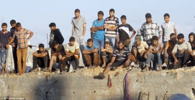 Mourning: Palestinians watch as rescue workers find the body of a member of al-Najar family, after removing it from under the rubble of their home