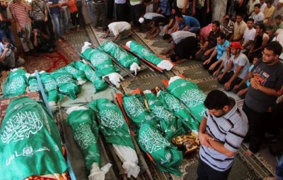 Palestinians pray over the bodies of 17 members of the Abu Jamea family, killed by an Israeli strike at their house, during their funeral at the main mosque in Khan Younis, in the southern Gaza Strip, Monday, July 21, 2014. (AP Photo/Hatem Ali)