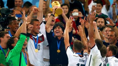 Germany Coach Joachim Loew raises the World Cup trophy as he's surrounded by his players following their 1-0 victory over Argentina in the championship game on Sunday at Maracana Stadium in Rio de Janeiro. (Clive Rose / Getty Images)