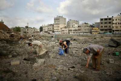 Palestinians search for scattered body parts amongst the rubble of Tayseer Al-Batsh's family house, which police said was destroyed in an Israeli air strike in Gaza City July 13, 2014.  REUTERS/Mohammed Salem