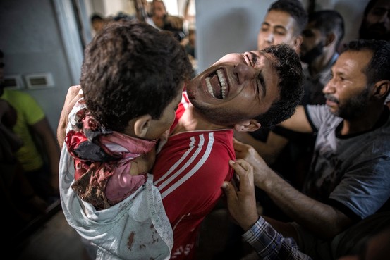 A grieving Palestinian youth holds the dead body of his younger brother, one of four boys killed in an Israeli attack on a beach in Gaza City. Oliver Weiken/European Pressphoto Agency