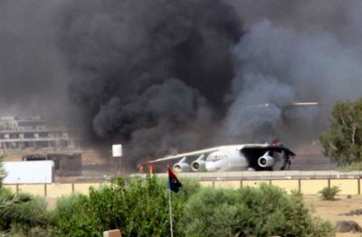 In this Saturday, July 26, 2014 frame grab from video obtained from a freelance journalist traveling with the Misarata brigade, shows an airplane on the tarmac of the airport belching black smoke into the air during fighting between the Islamist Misarata brigade and a powerful rival militia, in Tripoli, Libya. 